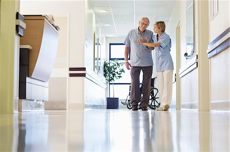 senior patient man - Nurse helping patient walk in hospital hallway Stock Photo - Premium Royalty-Free, Code: 6113-06908226