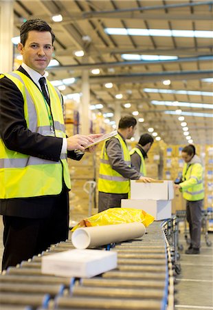 Workers checking packages on conveyor belt in warehouse Photographie de stock - Premium Libres de Droits, Code: 6113-06908358