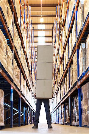 dificuldades - Worker holding boxes in warehouse Foto de stock - Sin royalties Premium, Código: 6113-06908391