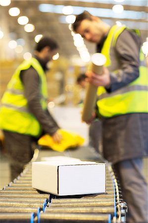 simsearch:6113-06908393,k - Workers checking packages on conveyor belt in warehouse Fotografie stock - Premium Royalty-Free, Codice: 6113-06908398