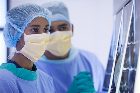 female asian medical gloves - Surgeons examining x-rays in hospital room Stock Photo - Premium Royalty-Free, Code: 6113-06908300