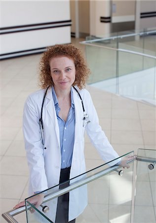 simsearch:6113-06908273,k - Doctor leaning on banister in hospital hallway Fotografie stock - Premium Royalty-Free, Codice: 6113-06908310