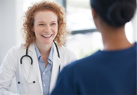 Doctor and nurse talking in hospital hallway Stock Photo - Premium Royalty-Free, Code: 6113-06908321