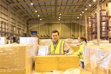 simsearch:6113-06908353,k - Worker unpacking boxes in warehouse Foto de stock - Sin royalties Premium, Código: 6113-06908339