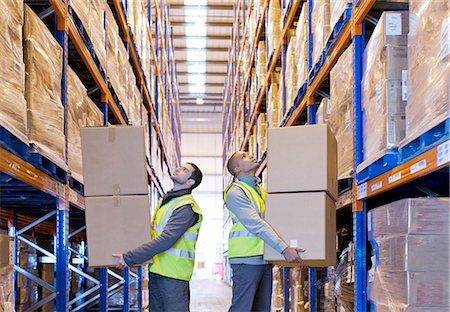 Workers carrying boxes in warehouse Stock Photo - Premium Royalty-Free, Code: 6113-06908440