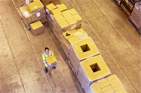 Worker carrying box in warehouse Photographie de stock - Premium Libres de Droits, Code: 6113-06908459