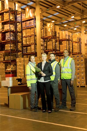 simsearch:6113-06908404,k - Businesswoman and workers smiling in warehouse Photographie de stock - Premium Libres de Droits, Code: 6113-06908467