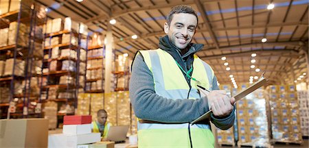 Worker writing on clipboard in warehouse Stock Photo - Premium Royalty-Free, Code: 6113-06908480