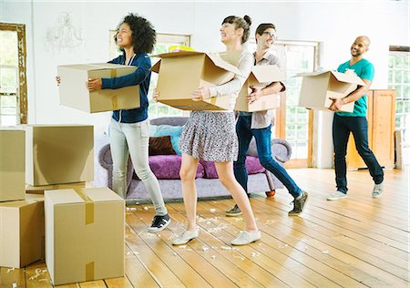 Friends unpacking boxes in new home Foto de stock - Royalty Free Premium, Número: 6113-06908485