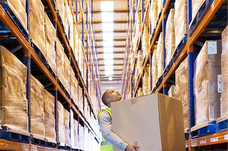 shipping industry - Worker carrying box in warehouse Stock Photo - Premium Royalty-Free, Code: 6113-06908433