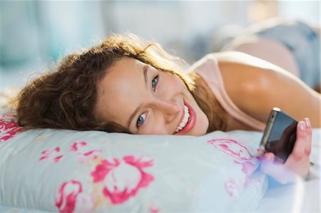 Woman using cell phone in bed Stock Photo - Premium Royalty-Free, Code: 6113-06908566