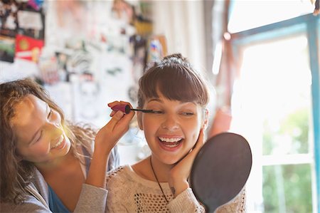 photo joyful - Woman applying makeup to friend's eyes in bedroom Stock Photo - Premium Royalty-Free, Code: 6113-06908513