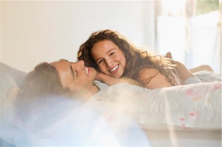 simsearch:6113-06908528,k - Couple relaxing together in bed Stock Photo - Premium Royalty-Free, Code: 6113-06908525