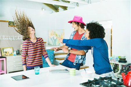 Friends playing together in kitchen Stock Photo - Premium Royalty-Free, Code: 6113-06908643