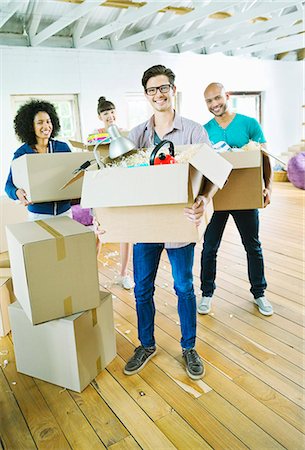 Friends unpacking boxes in new home Stock Photo - Premium Royalty-Free, Code: 6113-06908665