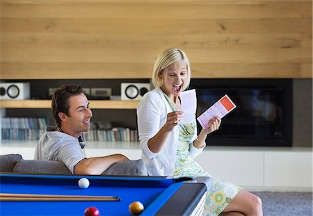 financial happiness - Couple checking lottery tickets on sofa Stock Photo - Premium Royalty-Free, Code: 6113-06908698