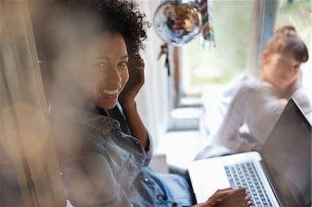 Woman using laptop in window Stock Photo - Premium Royalty-Free, Code: 6113-06908612