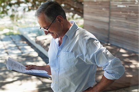 reading glasses top view - Businessman reading papers outdoors Stock Photo - Premium Royalty-Free, Code: 6113-06908746