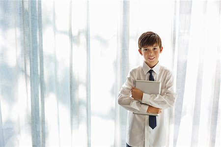Boy in shirt and tie holding tablet computer Stock Photo - Premium Royalty-Free, Code: 6113-06908765