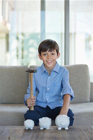 simsearch:649-03774573,k - Boy holding hammer to smash piggy banks Foto de stock - Royalty Free Premium, Número: 6113-06908776