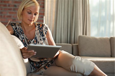 Woman using tablet computer on sofa Photographie de stock - Premium Libres de Droits, Code: 6113-06908781