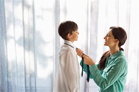 sich fertig machen - Mother tying son's tie at window Photographie de stock - Premium Libres de Droits, Code: 6113-06908730