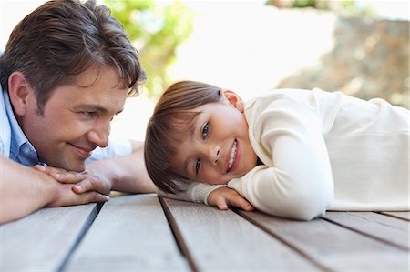 father and daughter - Father and daughter laying on porch Photographie de stock - Premium Libres de Droits, Code: 6113-06908845