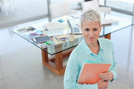 Businesswoman smiling in office Stock Photo - Premium Royalty-Free, Code: 6113-06908856