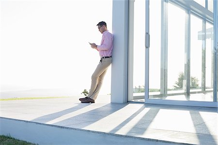 patio - Businessman using cell phone outside office Stock Photo - Premium Royalty-Free, Code: 6113-06908959