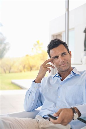 Businessman watching television in office Stock Photo - Premium Royalty-Free, Code: 6113-06908960