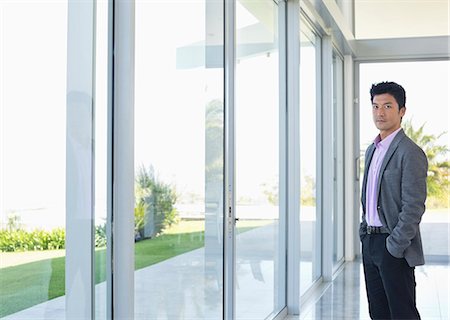 standing at window - Businessman standing at office window Stock Photo - Premium Royalty-Free, Code: 6113-06908968