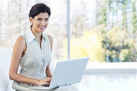 simsearch:6113-06908990,k - Businesswoman using laptop in office Photographie de stock - Premium Libres de Droits, Code: 6113-06908970