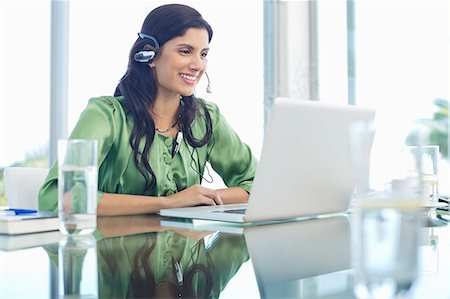 simsearch:6113-06908970,k - Businesswoman listening to headphones at desk Photographie de stock - Premium Libres de Droits, Code: 6113-06908990