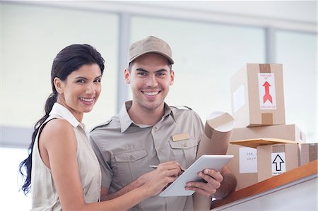 Woman signing for packages from delivery boy Stock Photo - Premium Royalty-Free, Code: 6113-06908907