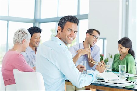 Businessman smiling in lunch meeting Stock Photo - Premium Royalty-Free, Code: 6113-06909041