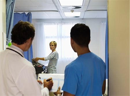 simsearch:6113-07762074,k - Doctor and nurse watching patient pack in hospital room Stock Photo - Premium Royalty-Free, Code: 6113-06909066