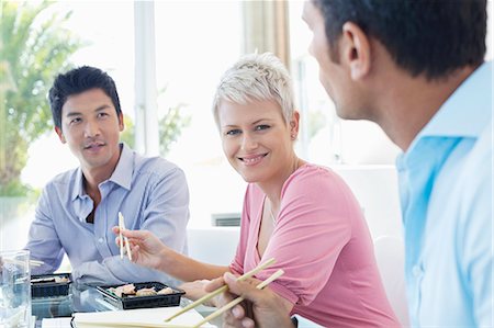 Business people eating sushi in office Stock Photo - Premium Royalty-Free, Code: 6113-06909003