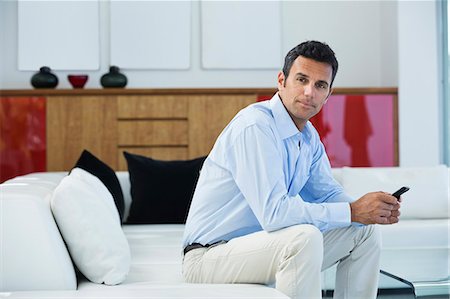 serious male looking at camera - Businessman sitting on sofa Stock Photo - Premium Royalty-Free, Code: 6113-06909005