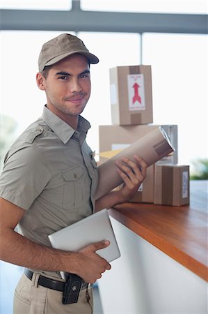 Delivery boy with packages in office Photographie de stock - Premium Libres de Droits, Code: 6113-06909025