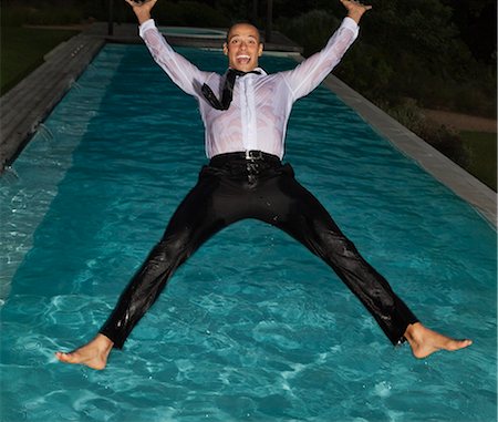 Fully dressed man jumping into swimming pool Foto de stock - Sin royalties Premium, Código: 6113-06909146