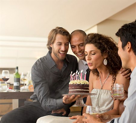 people holding candle - Woman blowing out birthday candles Photographie de stock - Premium Libres de Droits, Code: 6113-06909166