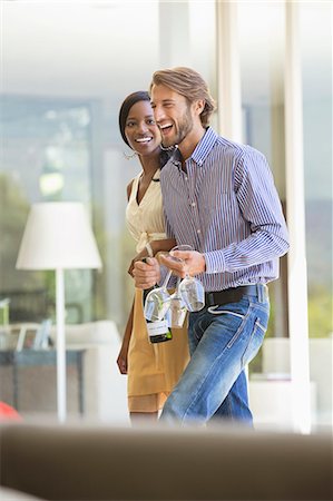 simsearch:6113-06909143,k - Couple carrying wine bottle and glasses Stock Photo - Premium Royalty-Free, Code: 6113-06909115