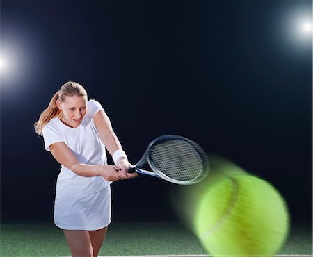 Tennis player hitting ball on court Stock Photo - Premium Royalty-Free, Code: 6113-06909283