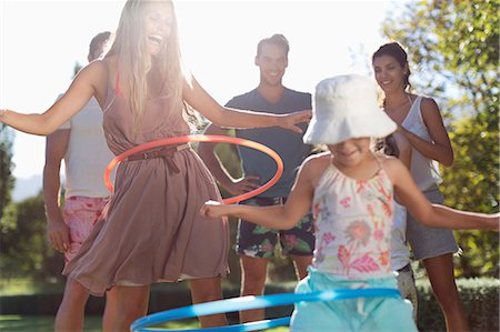 Girls hula hooping in backyard Foto de stock - Sin royalties Premium, Código: 6113-06909299