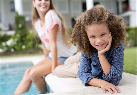 simsearch:6113-06909372,k - Mother and daughter relaxing by swimming pool Stock Photo - Premium Royalty-Free, Code: 6113-06909358