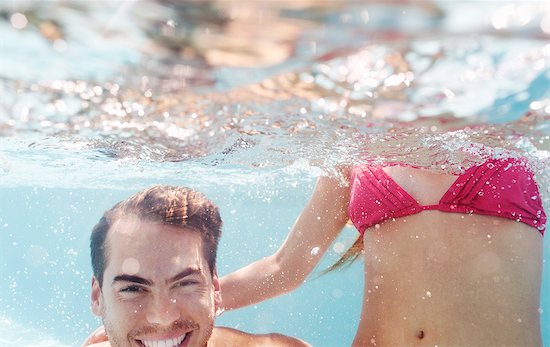 Couple playing in swimming pool Stock Photo - Premium Royalty-Free, Image code: 6113-06909324