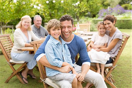 simsearch:6113-06909445,k - Family smiling at table outdoors Stock Photo - Premium Royalty-Free, Code: 6113-06909443