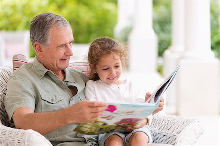 simsearch:6113-06626338,k - Older man reading to granddaughter on porch Stock Photo - Premium Royalty-Free, Code: 6113-06909463