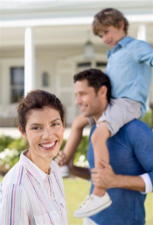 father carrying child - Family smiling outside house Stock Photo - Premium Royalty-Free, Code: 6113-06909410