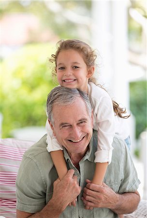 Older man carrying granddaughter piggyback Stock Photo - Premium Royalty-Free, Code: 6113-06909429